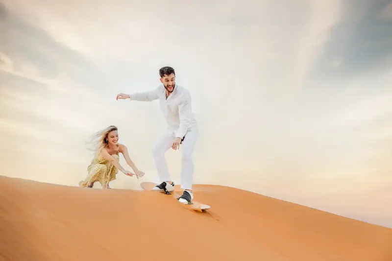 Couple celebrating a desert proposal on Dubai sand dunes at golden hour