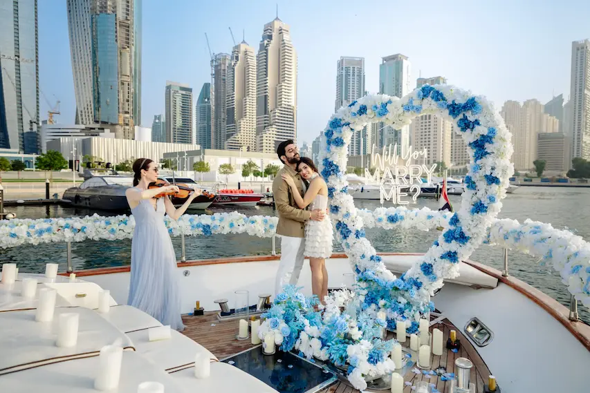 Luxury yacht proposal in Dubai Marina with floral heart arch and Will You Marry Me sign