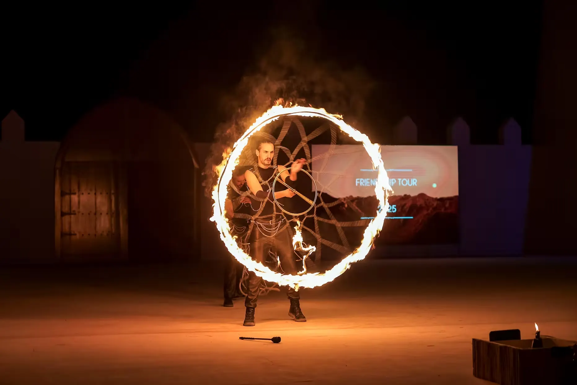 Fire performer spinning a flaming hoop on stage at a corporate desert event in Dubai